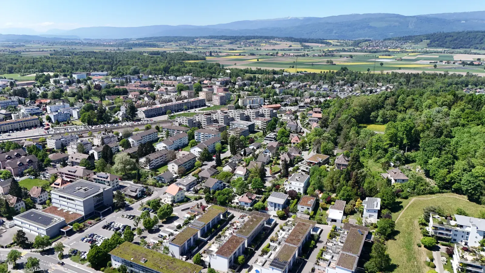 Luftaufnahme Lyss mit Wohnquartieren und Jura im Hintergrund