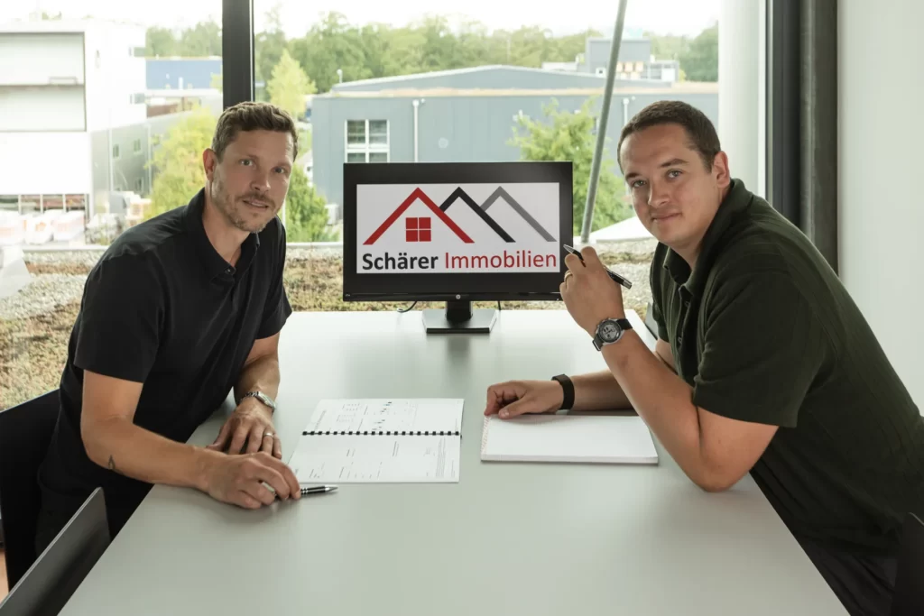 Noah Schärer und Lukas Pauli besprechen Unterlagen zu einer Immobilie im Büro in Lyss