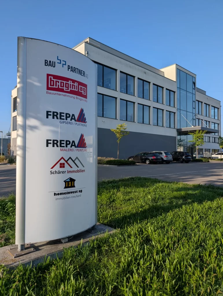Standort der Schärer Immobilien AG an der Südstrasse 8 in Lyss mit Firmenstele vor dem Geschäftshaus